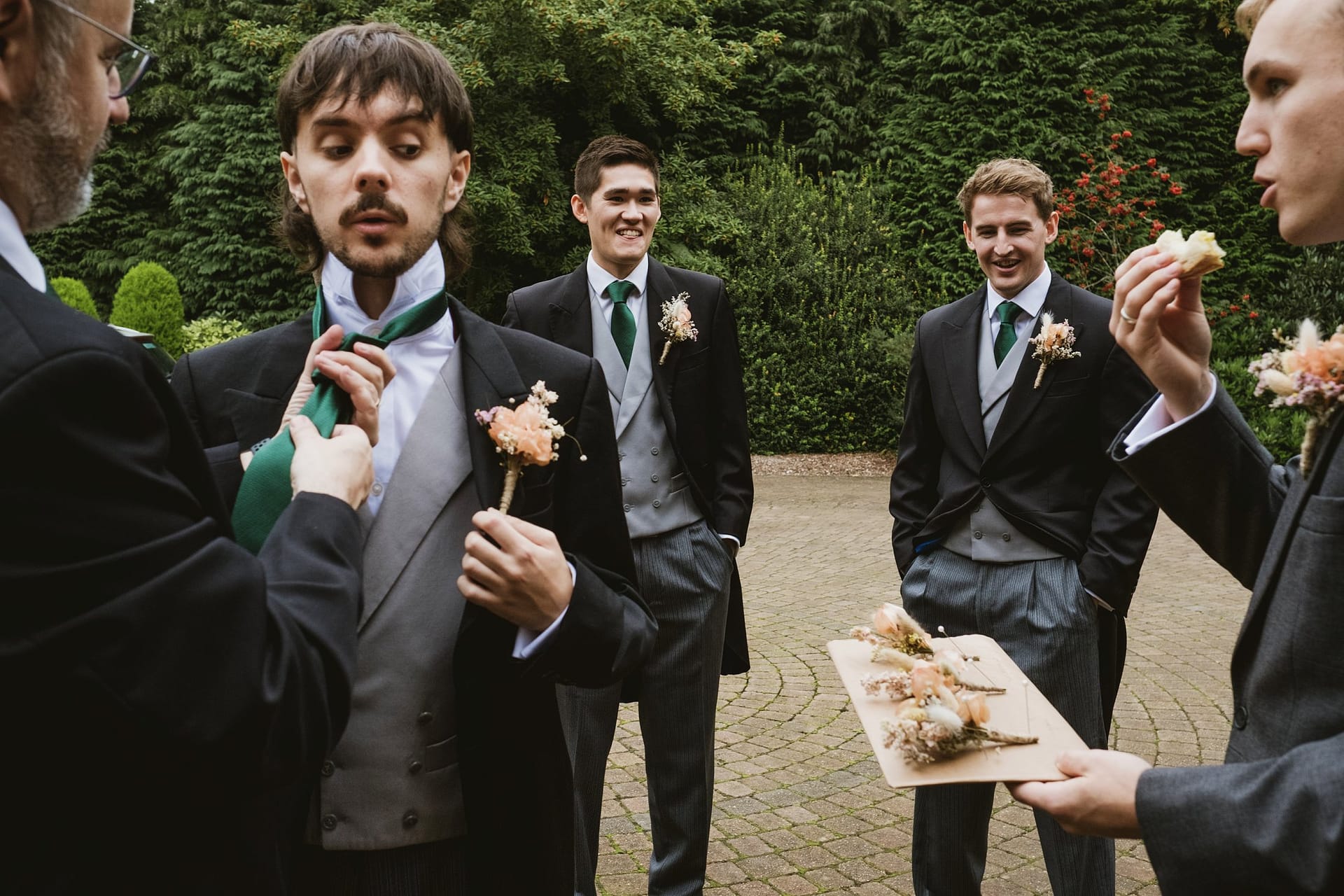 groomsmen having his tie done by another groomsmen