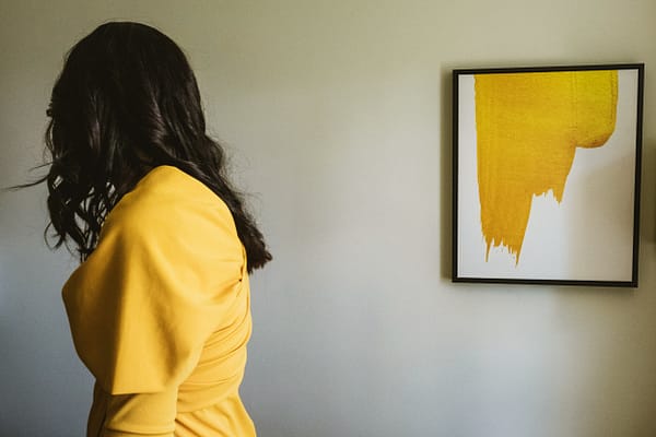 street style photography - a yellow dress matches a yellow modern art painting on the wall during the bridal preparations