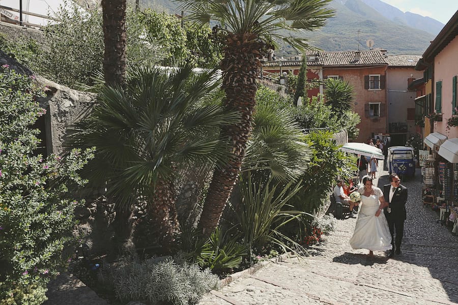 Bride and her father arrive for a wedding at Malcesine Castle, Italy