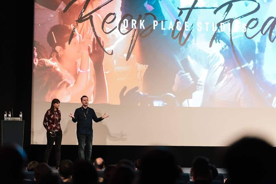 Speaking events by York Place - Photographers Dominique & LIam Shaw stand on stage presenting during Keep It Real conference in Berlin