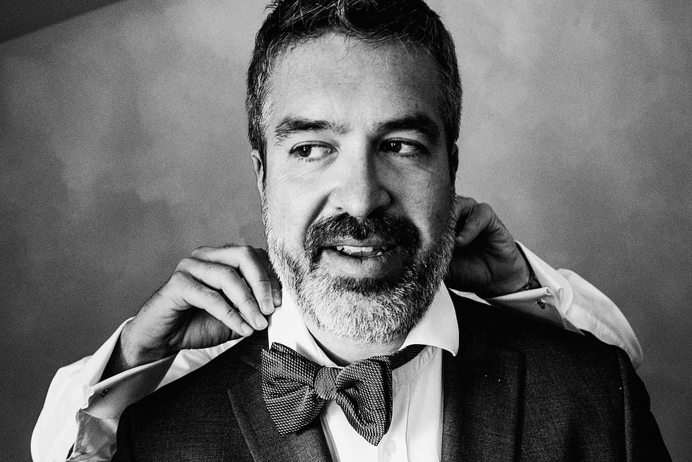 Groomsman having his bow tie tied. Wedding photography from Villa Love Krakow