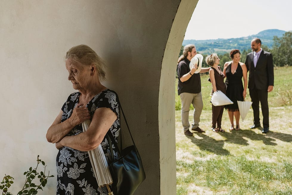 elderly guest waits in shade before Krakow wedding