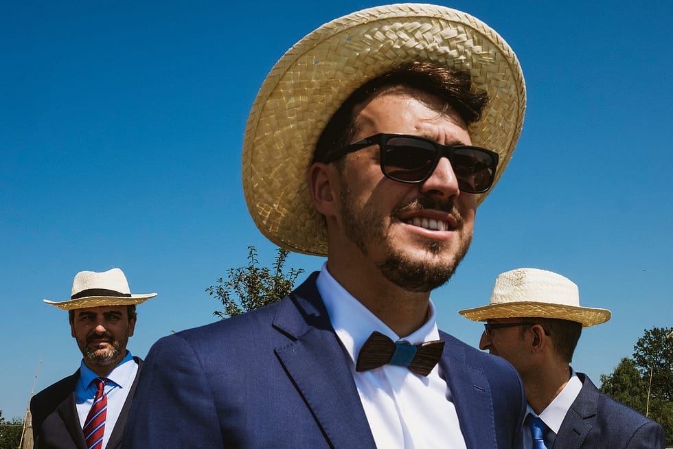 Three men in straw hats at Polish wedding