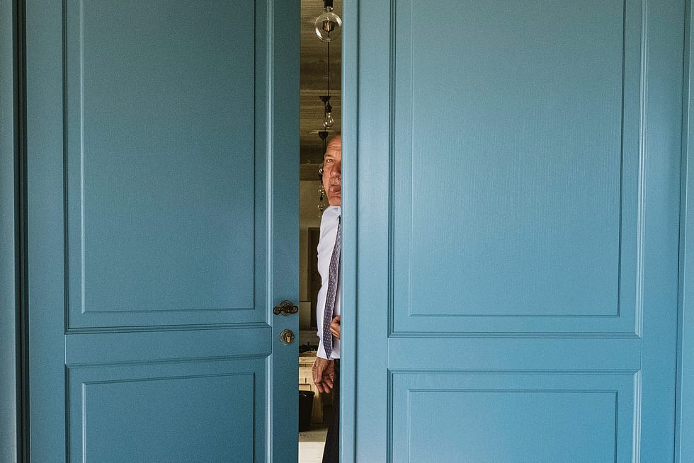 wedding photograph of guest through part-open door, Poland